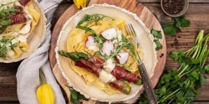 Beitragsbild des Blogbeitrags Bandnudeln mit cremiger Käsesauce und Spargel im Speckmantel