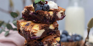 Beitragsbild des Blogbeitrags Schoko Cheesecake Brownies mit Heidelbeeren