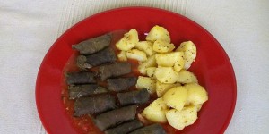 Beitragsbild des Blogbeitrags Vegane gefüllte Weinblätter mit Oregano-Kartoffeln auf Tomaten-Sauce - Griechenland