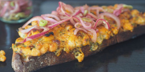 Beitragsbild des Blogbeitrags Weiße Bohnen auf geröstetem Brot mit Käse, Curry und eingelegten Zwiebeln 