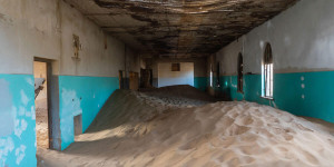 Beitragsbild des Blogbeitrags Kolmanskop in Namibia – die Diamantenstadt, die sich die Wüste wieder holt