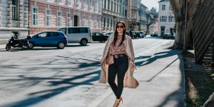 Beitragsbild des Blogbeitrags Outfit mit Trenchcoat, gemusterter Bluse, schwarzer Skinny Jeans und Pumps