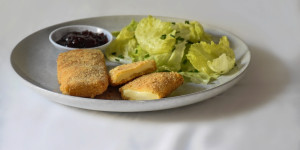 Beitragsbild des Blogbeitrags gebackener Käse mit Preiselbeermarmelade und Blattsalat 