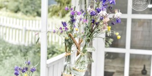 Beitragsbild des Blogbeitrags Gartendeko selbermachen - Flaschenvasen am Stock