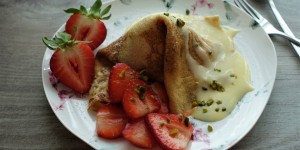 Beitragsbild des Blogbeitrags Nachhaltig und gut: (Erd-)Beerige Eis – Palatschinken mit Vanillesoße und Pistazien