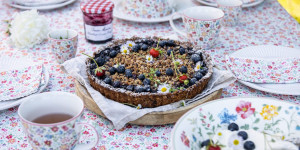 Beitragsbild des Blogbeitrags SOMMERLICHER FRUCHTGENUSS MIT BLUMIGEM TEE-KRÄNZCHEN! Heidelbeer-Knuspertarte zum Verlieben