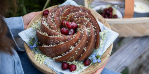 Beitragsbild des Blogbeitrags SAMTIG WEICHER SOMMERKUCHEN! Holunderblüten-Gugelhupf mit Kirschen & mein liebstes bio-faires Denim-Label 