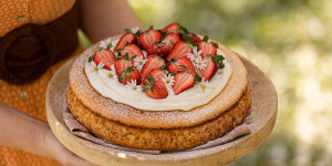 Beitragsbild des Blogbeitrags WIR FEIERN BALD MUTTERTAG! Süße Reistorte mit Holunder-Topfencreme und glücklichen Erdbeeren