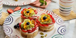 Beitragsbild des Blogbeitrags BUNTES SOMMERDESSERT IM REGENBOGEN-DESIGN! Obst-Törtchen mit Pistazienbiskuit und Vanillecreme
