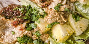 Beitragsbild des Blogbeitrags Asiatisches Erdnusshuhn mit Nudeln auf Salatblatt serviert!