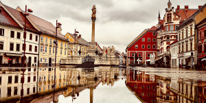 Beitragsbild des Blogbeitrags Spiegelung im Wasser der Pest Gedenksäule am Glavni trg Hauptplatz Maribor