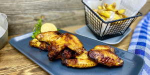 Beitragsbild des Blogbeitrags Chickenwings mit Honig & selbst gemachten Kräuter Pommes