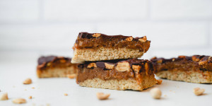 Beitragsbild des Blogbeitrags Vegane Snickers | Erdnuss-Karamell-Schokolade Riegel – einfach & so lecker! 
