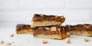 Beitragsbild des Blogbeitrags Vegane Snickers | Erdnuss-Karamell-Schokolade Riegel – einfach & so lecker!