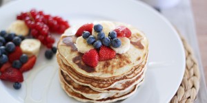 Beitragsbild des Blogbeitrags vegane Pancakes mit Bananen, Früchten und Agavendicksaft 