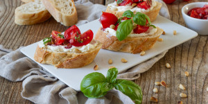Beitragsbild des Blogbeitrags Bruschetta mit Tomaten, Frischkäse und gerösteten Pinienkernen